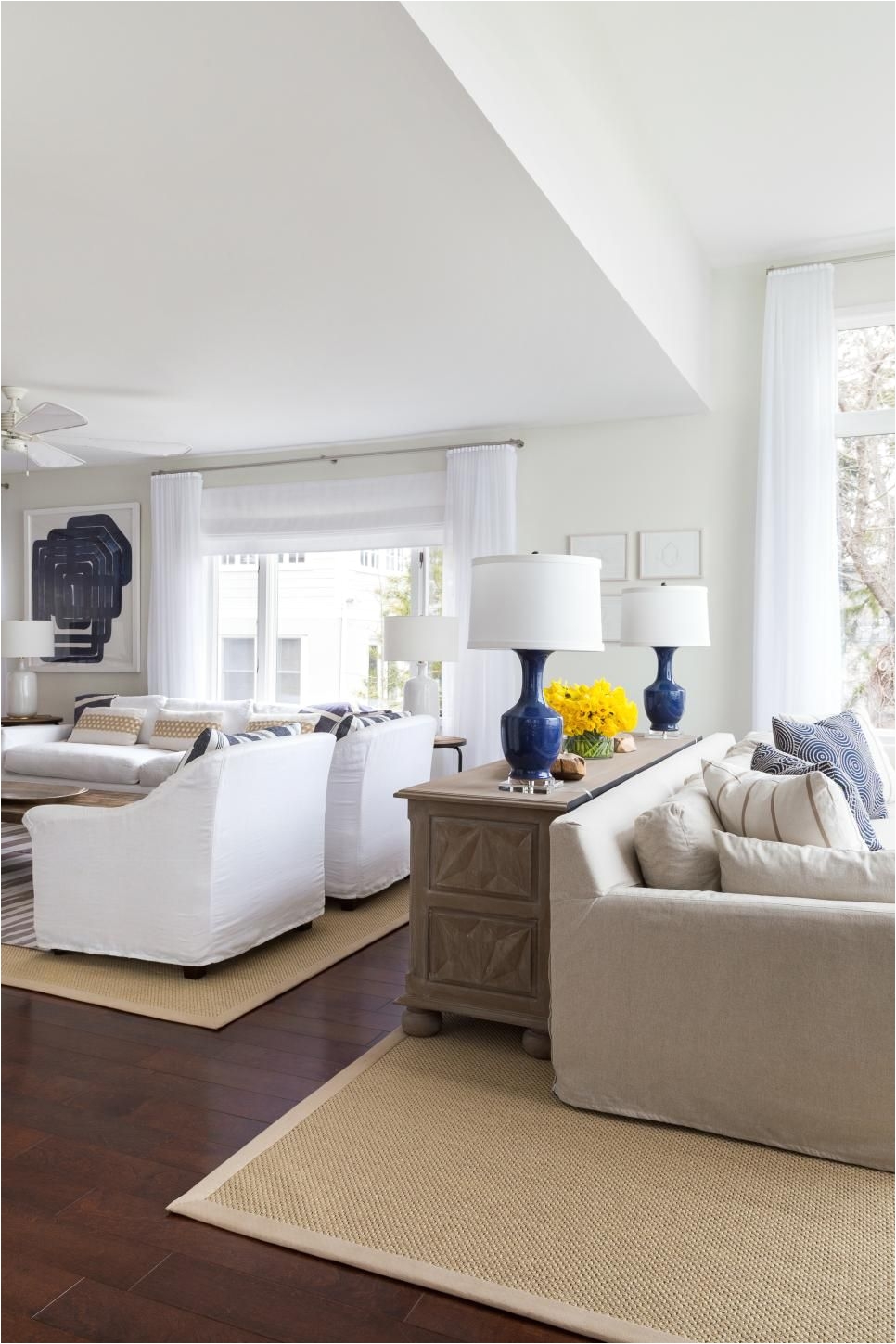 the formal living room is separated into two seating areas a reading nook and a larger conversational space sisal rugs help delineate the two sections as