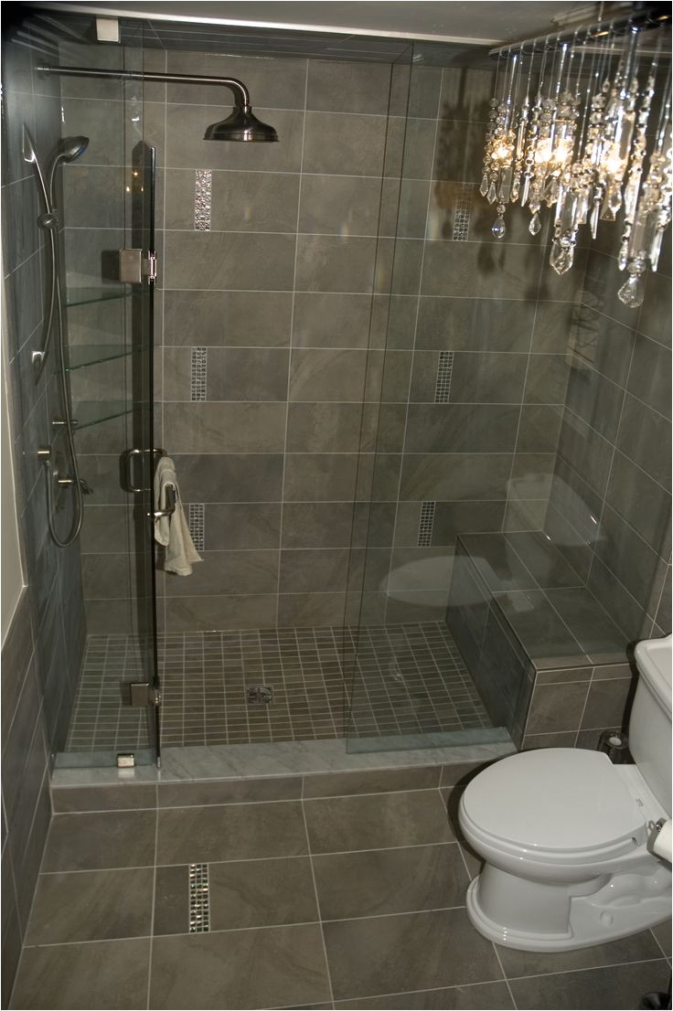 glamorous bathroom chandelier paired with small mosaic inserts in shower adds some bling and