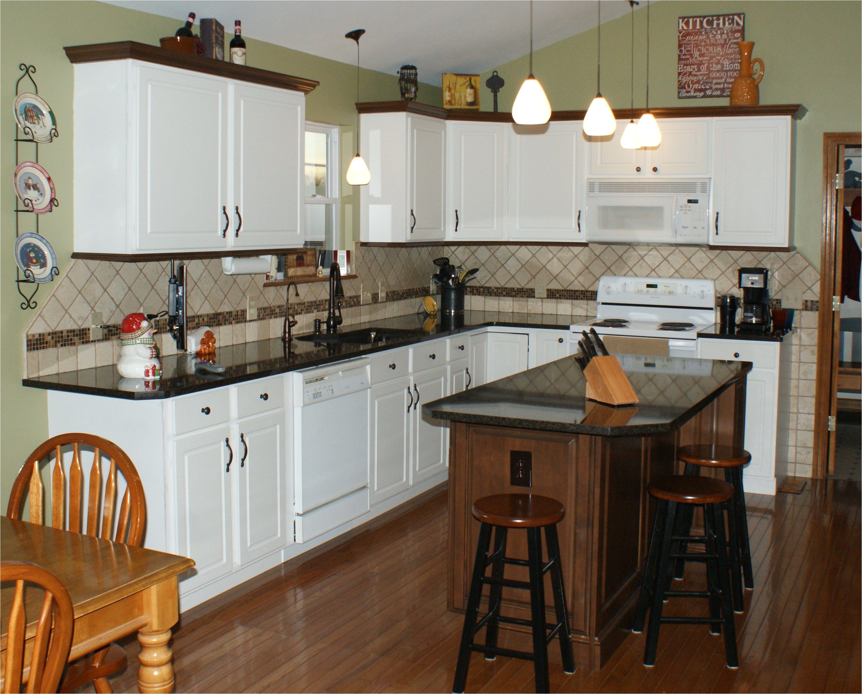 new brookhaven island nut brown on maple with matching molding added to existing white thermofoil cabinetry new cambria countertops