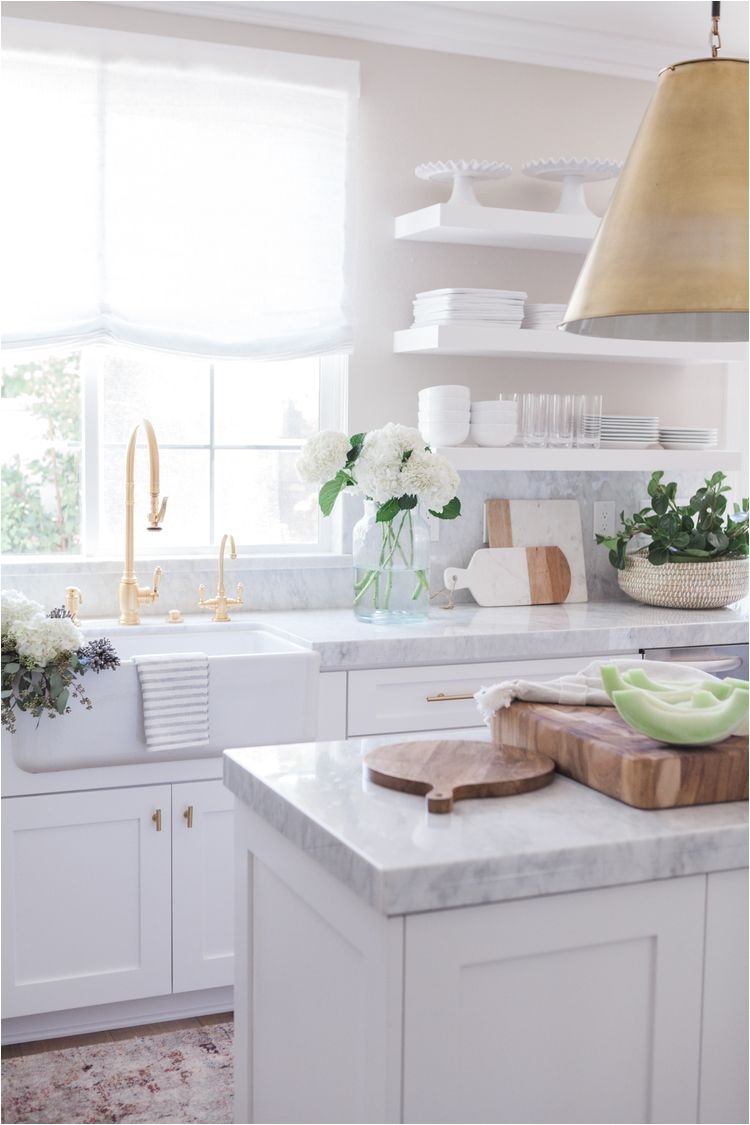 love the thick marble countertop gold faucet and white open shelving
