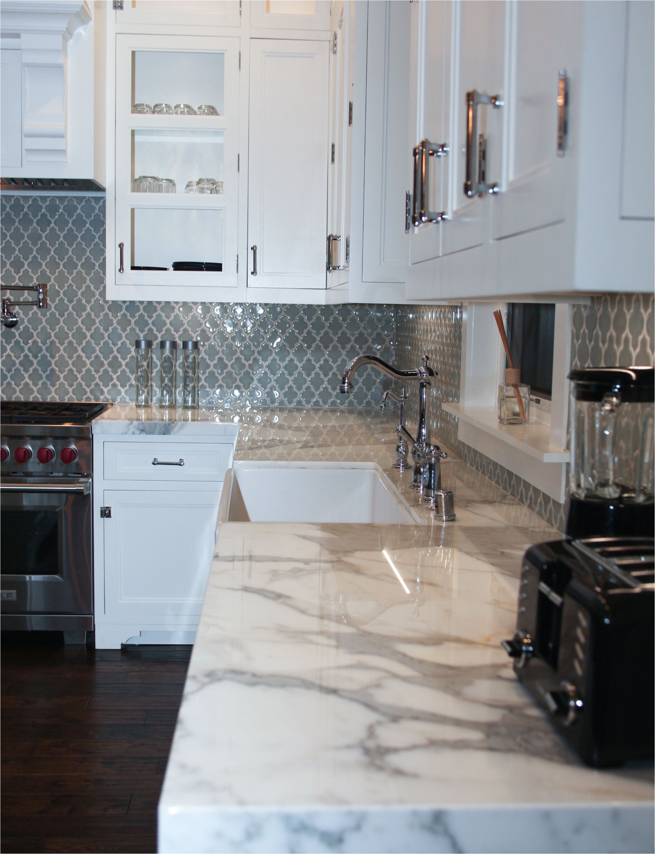 bluish grayish moroccan style tiles for the backsplash with calcutta marble countertops by mesa designs 310 955 6349