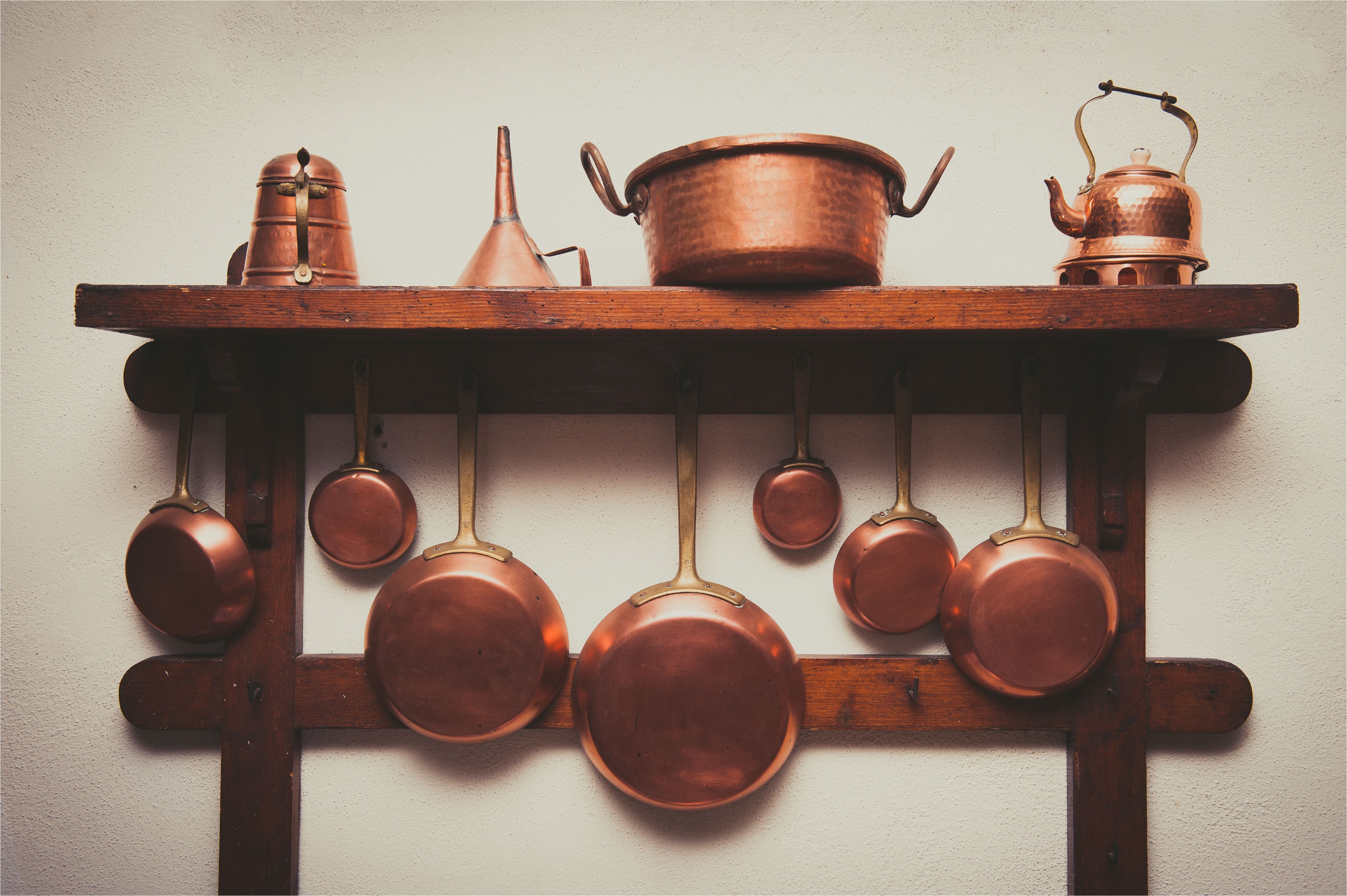 copper kitchen utensils arranged on shelf in kitchen 748567067 5a985da7ae9ab800378d1bff jpg