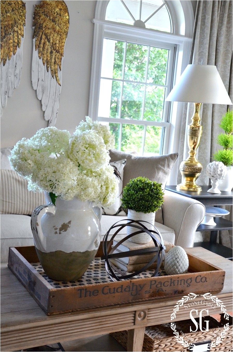 i love the idea of putting the coffee table decor on a wooden tray looks great and makes it easy to move out of the way when needed