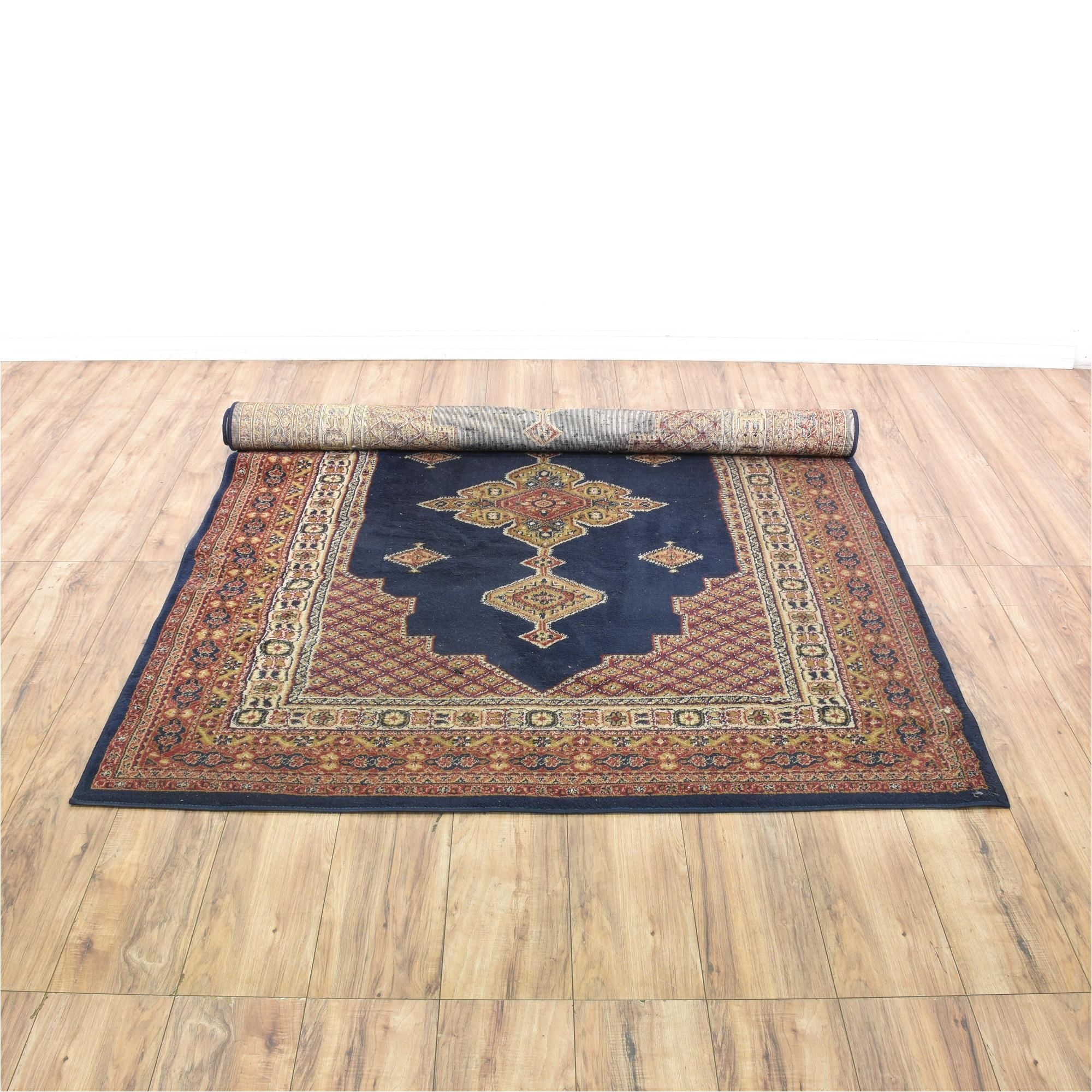 this bohemian rug is woven in a durable dark navy blue red and yellow gold finish this large area rug has striped border trim floral accents and center