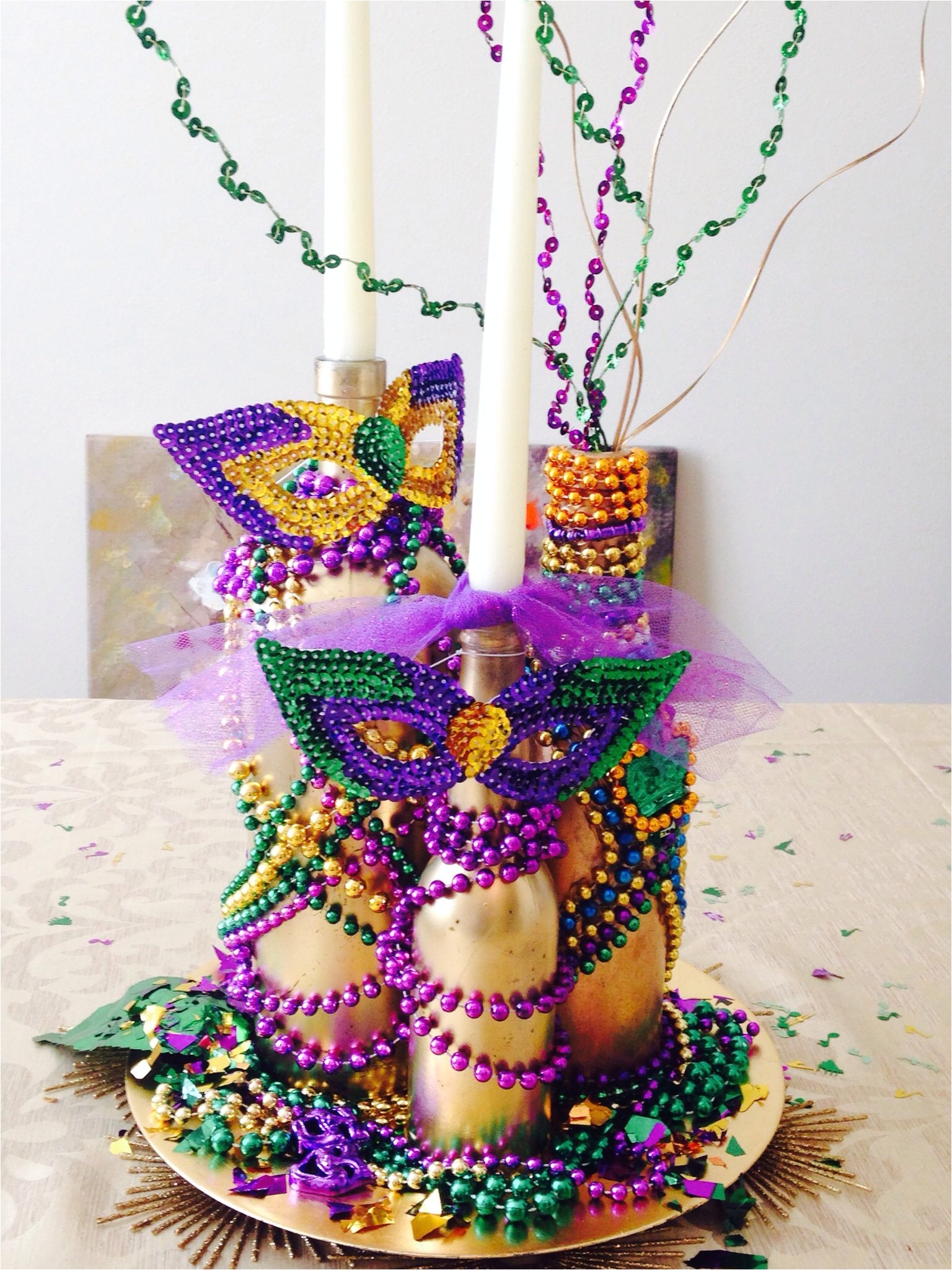 my mardi gras centerpiece glued beads to gold spray painted bottles and lots of mardi gras confetti fun