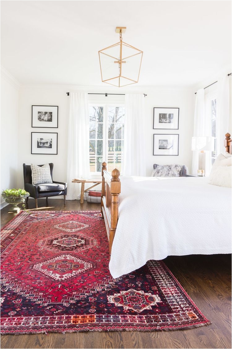 bedroom white walls white bedding antique rug seating