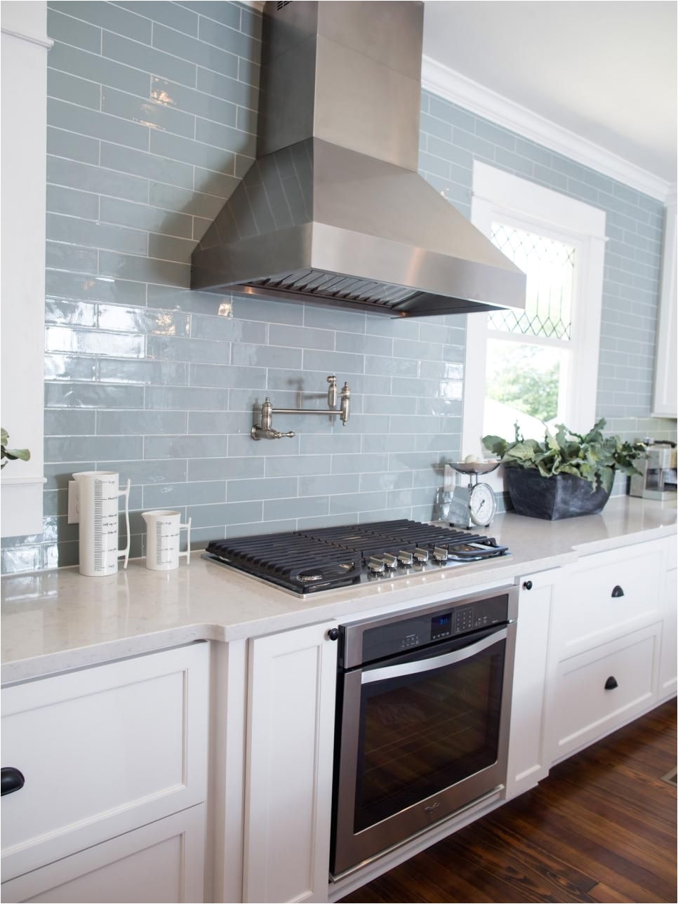 other key features in the new kitchen are stainless steel appliances vent hood and a subway tile backsplash in muted blue a favorite color of homeowner