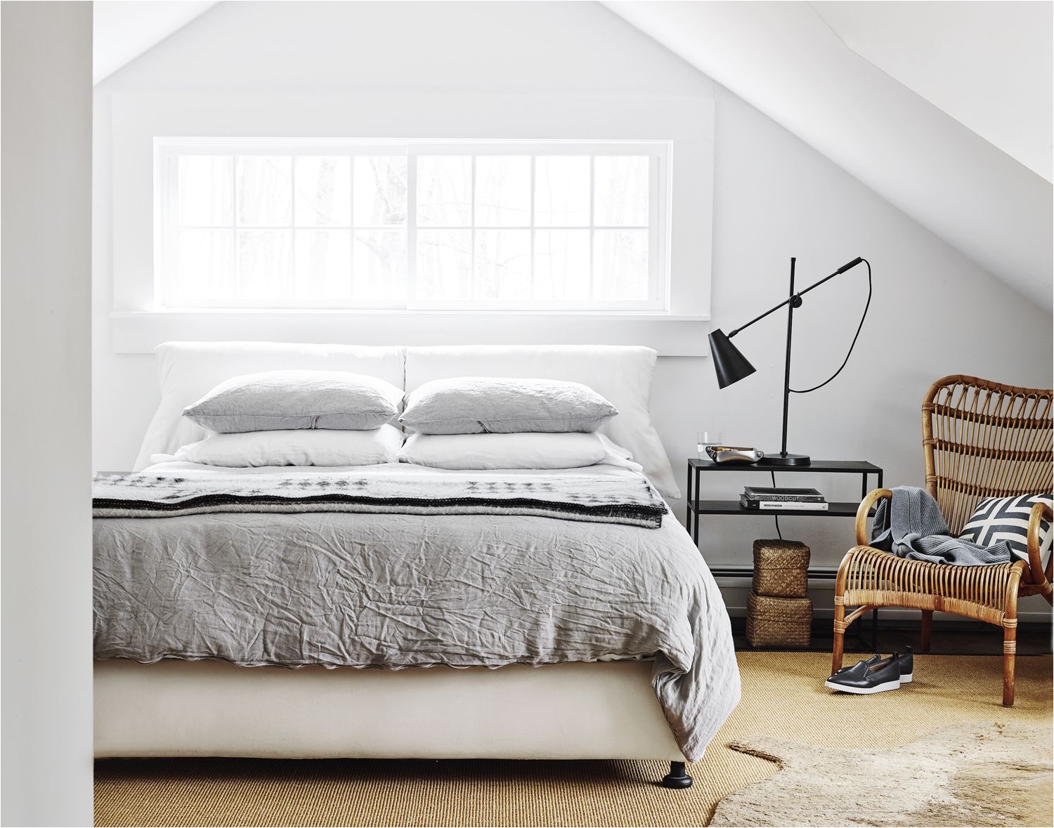 master bedroom grey linen bedding rattan chair sisal rug