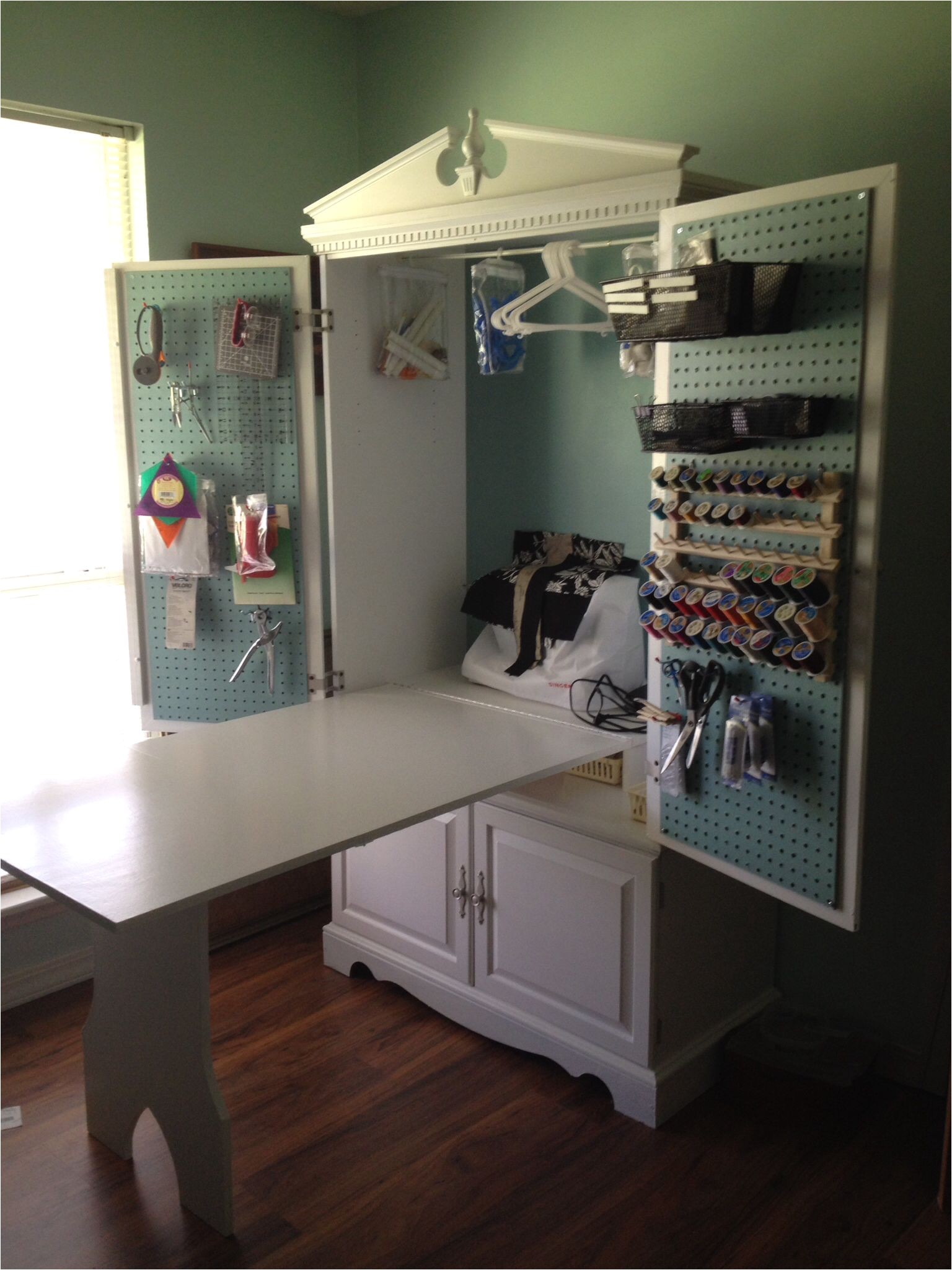 tv armoire turned into a sewing cabinet with fold up table