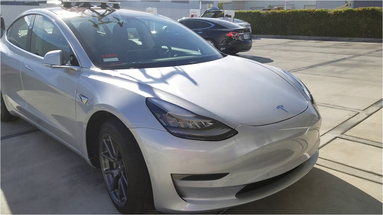 tesla model 3 with a bike on the roof