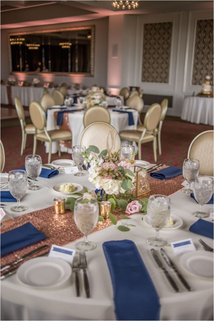 rose gold and navy wedding reception decor with low blush rose centerpiece with greenery navy