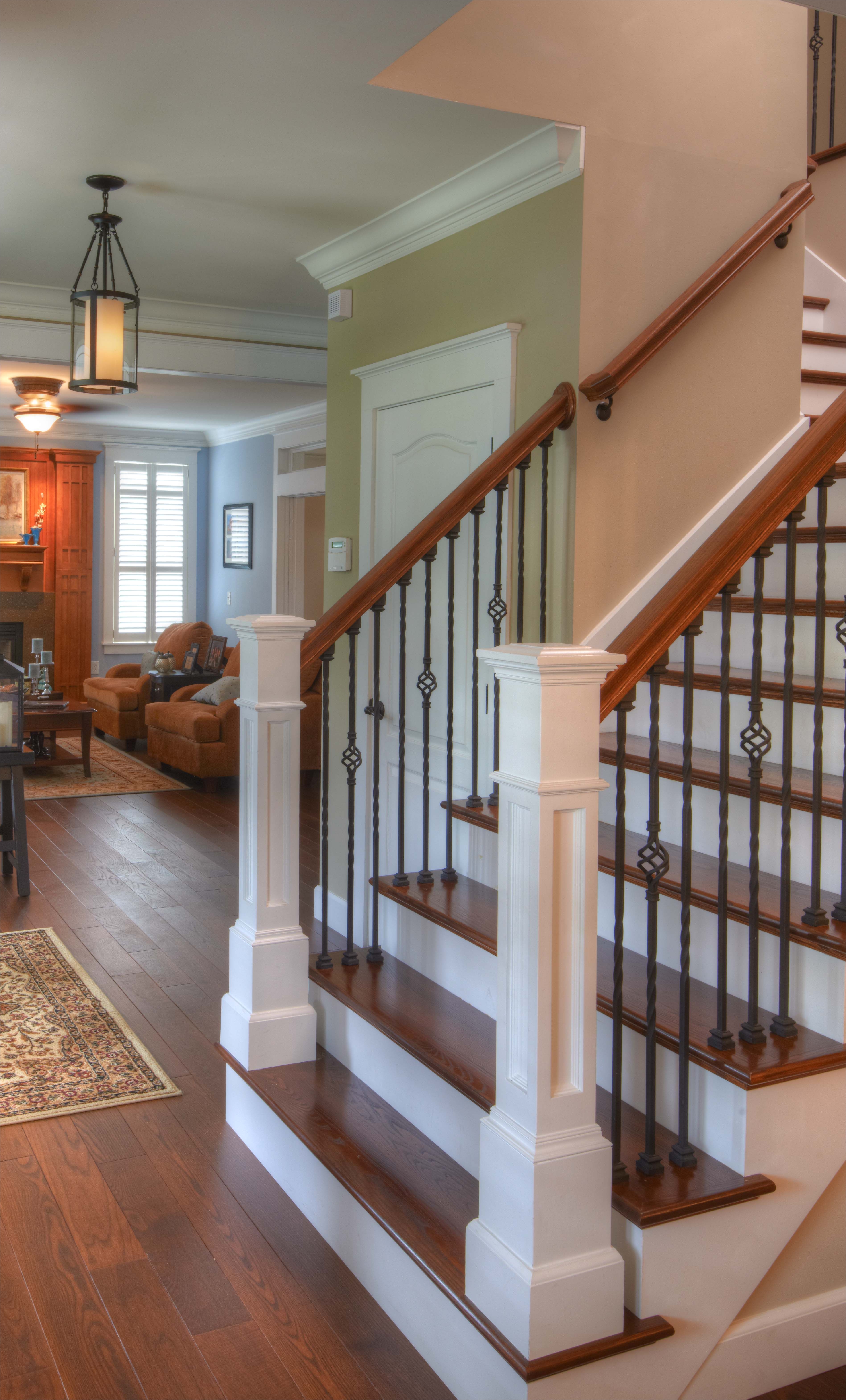 hardwood flooring up the stairs classic look rod iron balusters wood railings and white posts