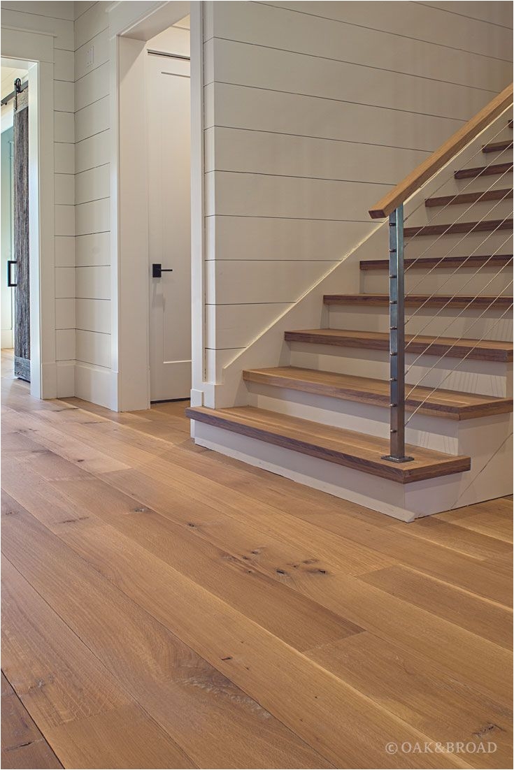 wide plank white oak hardwood floor by oak and broad with custom stain matching stair treads discover more at
