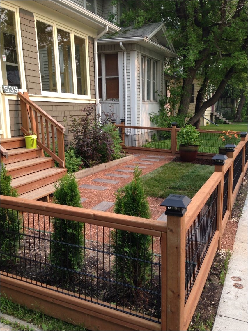 this sweet front yard is really made by the beautiful timber fence with stone path in similar tones via interior decorating ideas