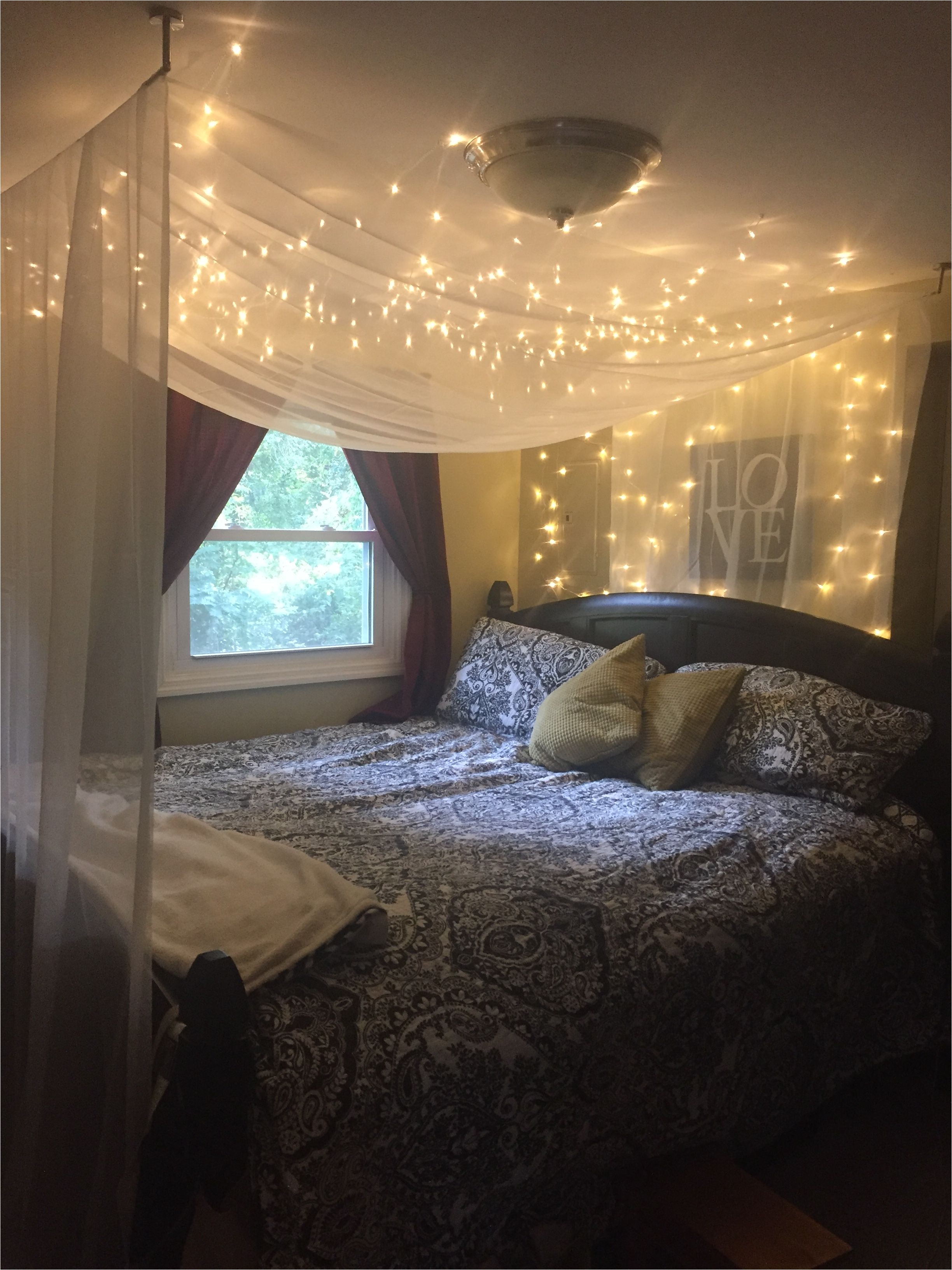 bedroom with black and white forter yellow accents red curtains christmas light bed