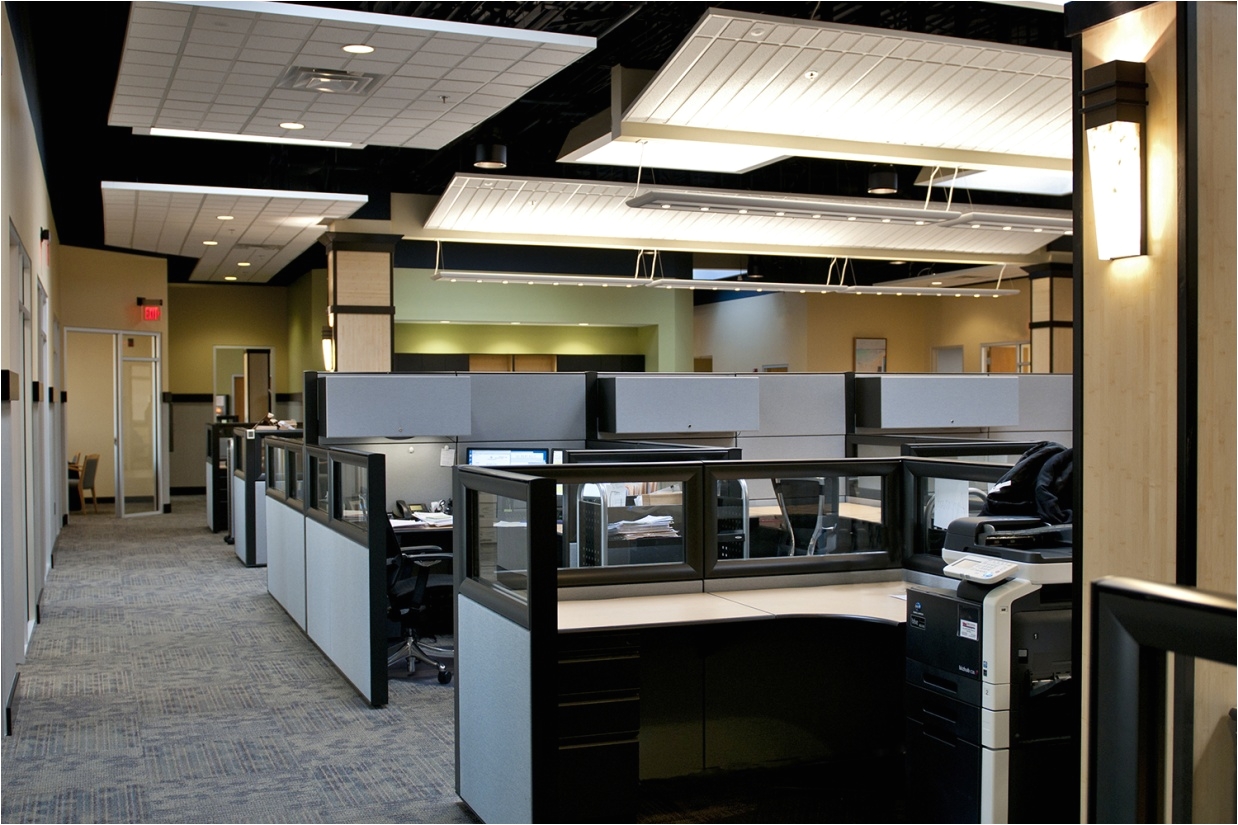 wedge sconces illuminate a modern office lighting design shown along the wall of an open