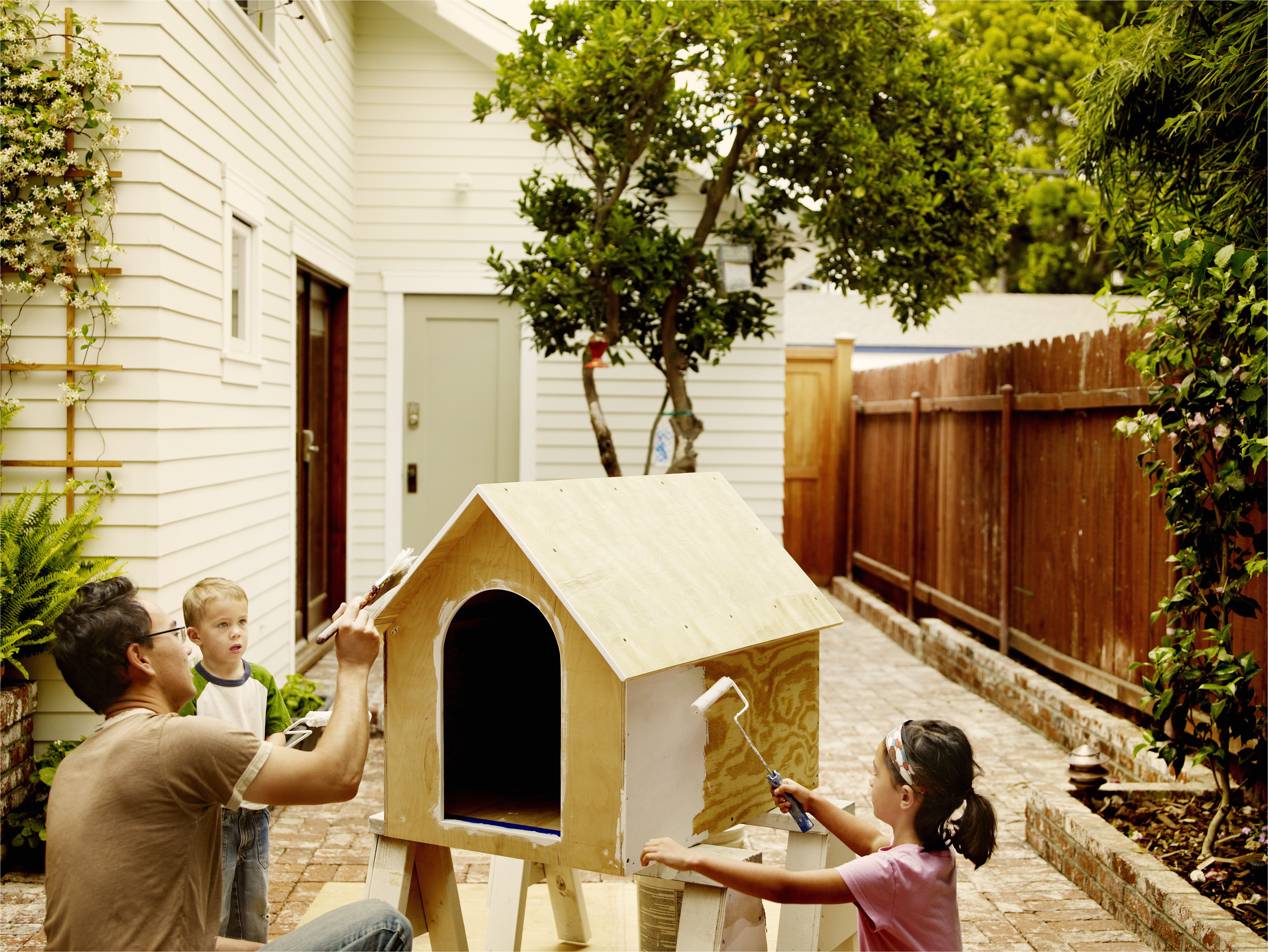 father and children work on dog house