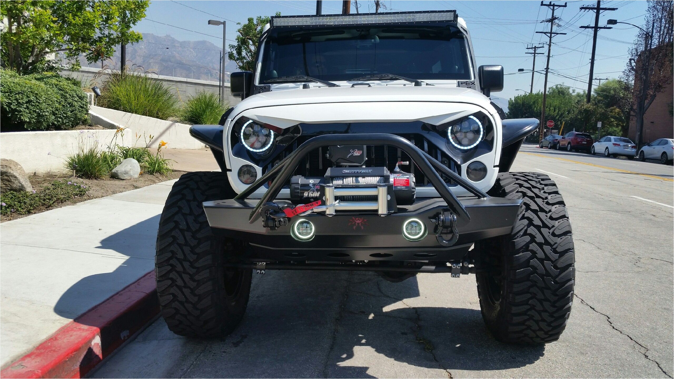 mean looking jeep jk with halo headlights poison spyder bumper new grille winch and a light bar