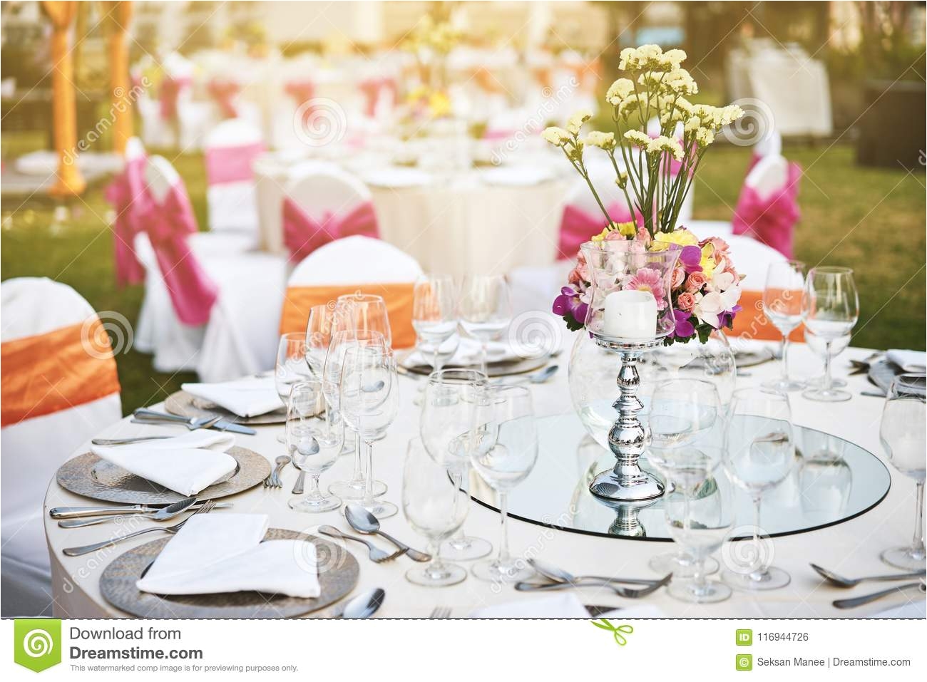 wedding reception dinner table setting outdoors with warm light during sunset