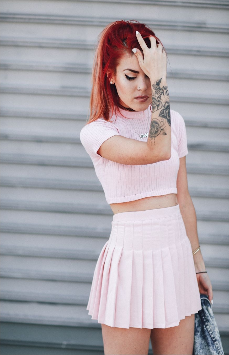 le happy wearing a pastel pink tennis skirt and unif crop top
