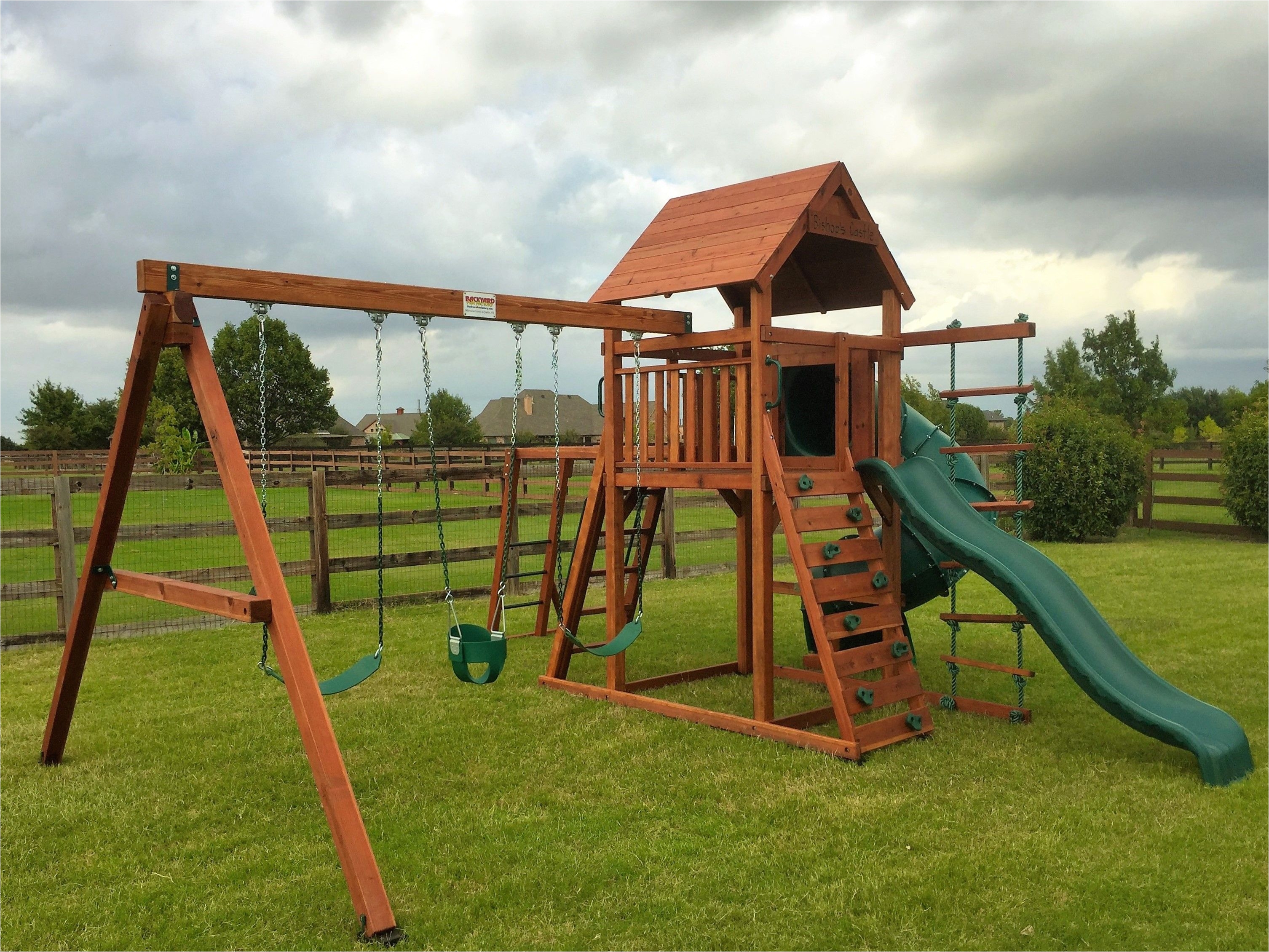 wrangler playset shown with spiral slide wave slide monkey bars deck ladder