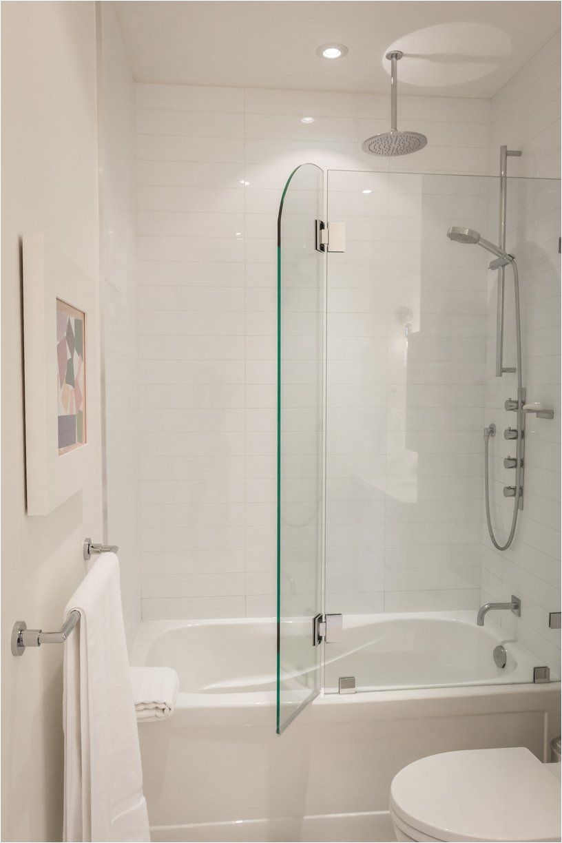 greg robs sky suite house tour toronto white bathroom with glass door that opens for shower in bathtub