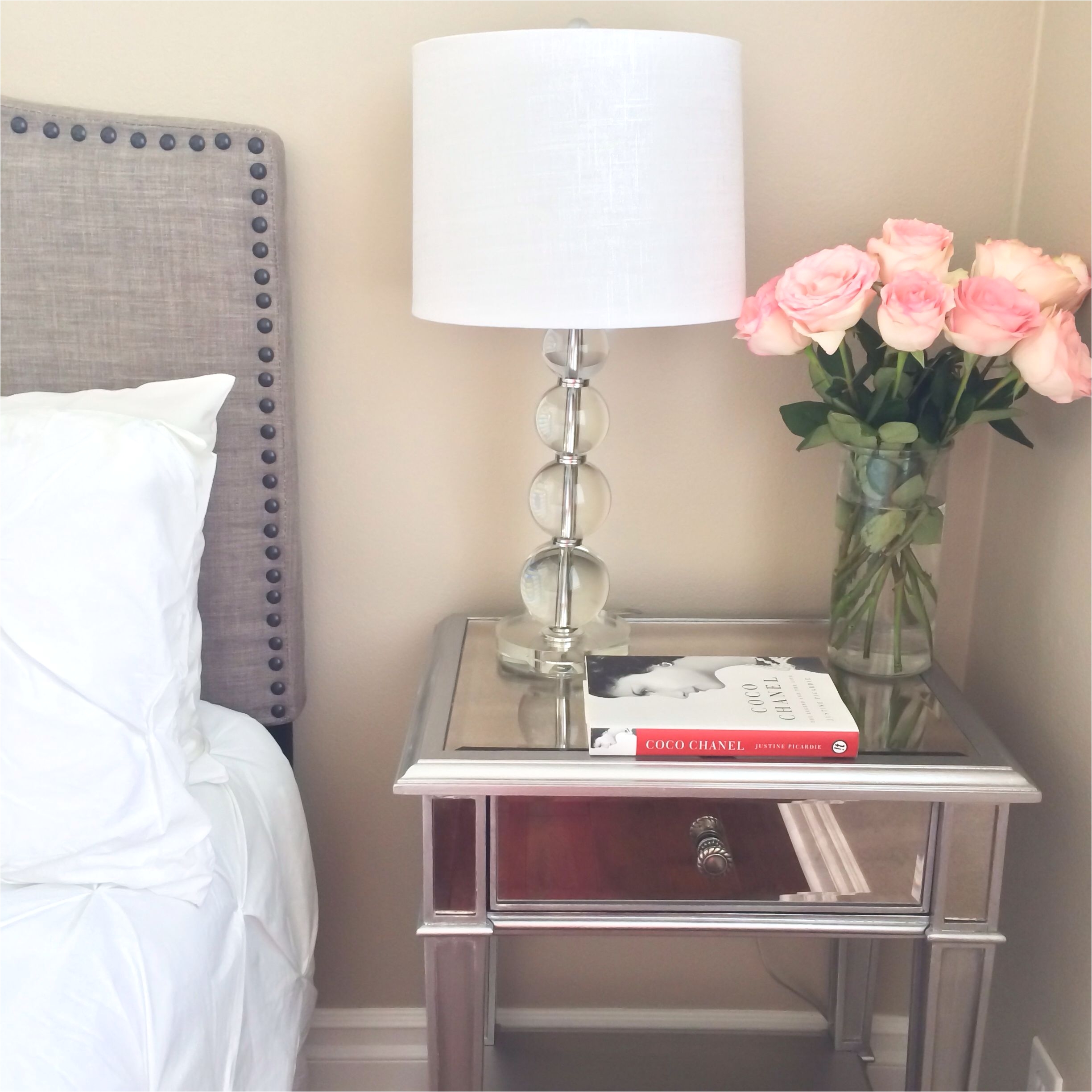 guest bedroom grey headboard with stud detail edging white tufted comforter set glass lamp mirrored nightstand and pink roses could still be good for