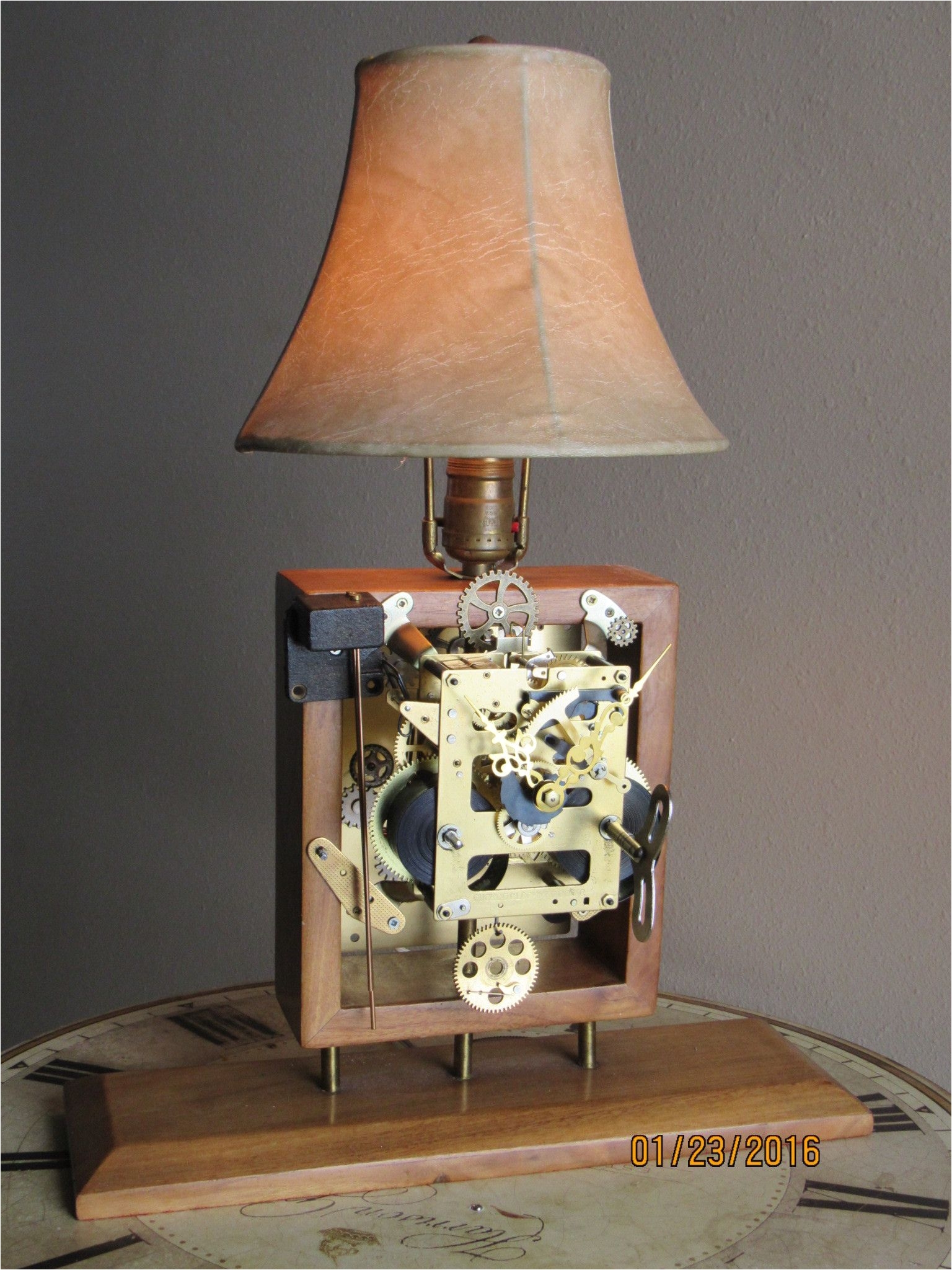 this lamp is not only beautiful the clockwork works you can wind the main spring the repurposed pendulum swings the chimes sound you can watch