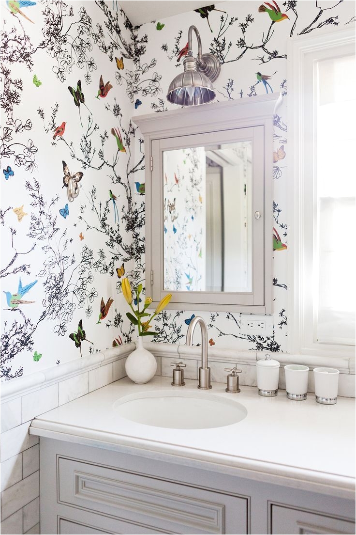 Feminine and light butterfly and floral wallpaper adorns the bathroom of a Los Angeles home
