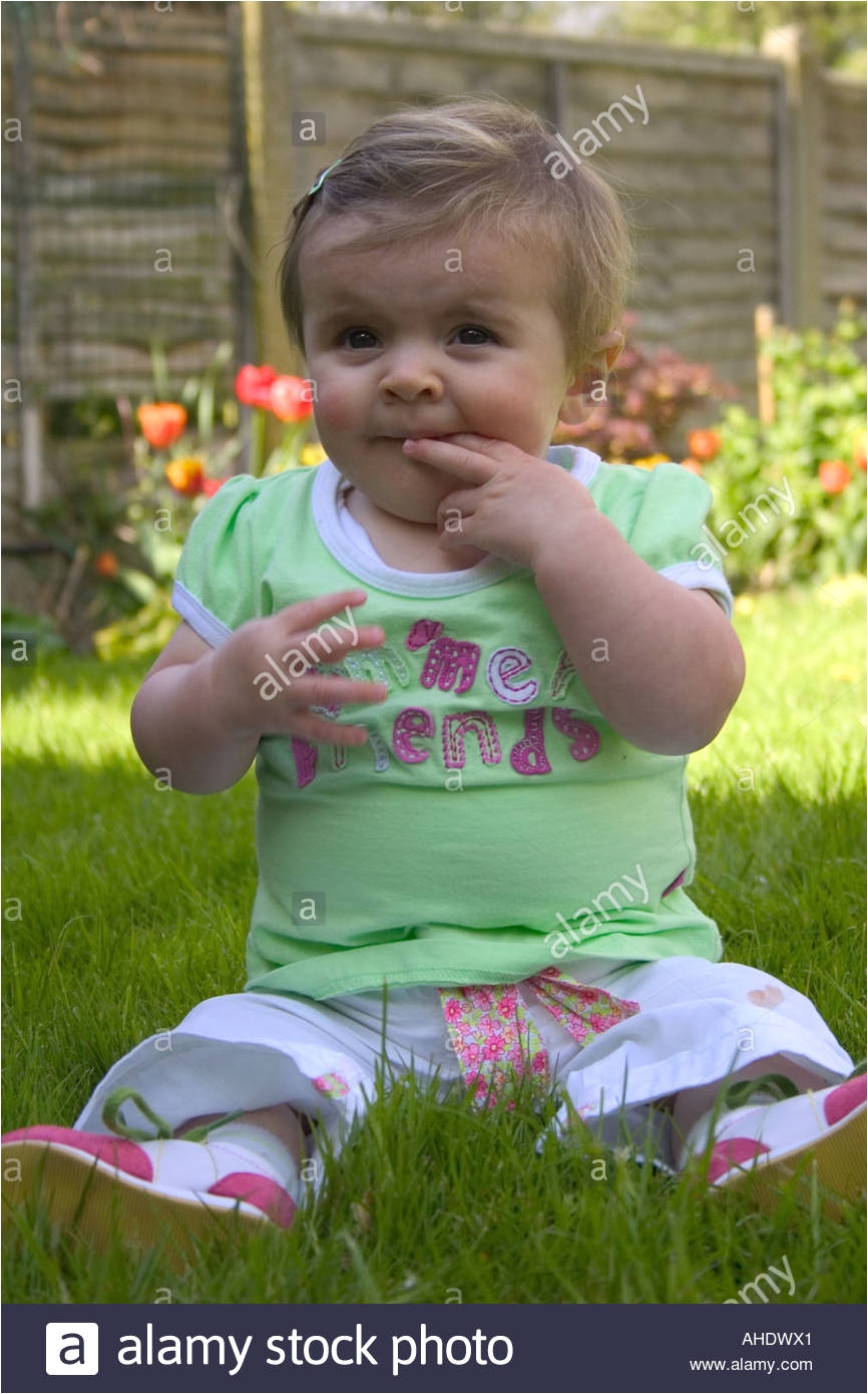 stock photo 7 month old baby girl eating grass