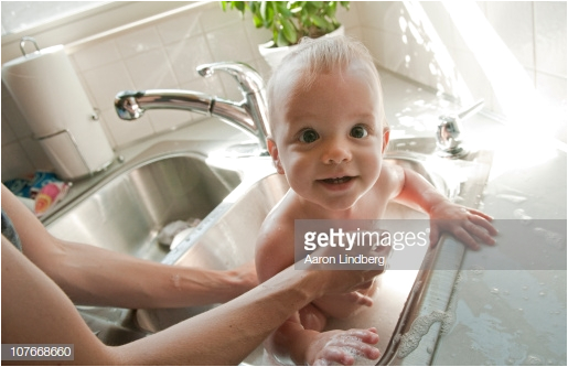 Baby Bathtub Kitchen Sink Baby Getting A Bath In Kitchen Sink From Mother Stock