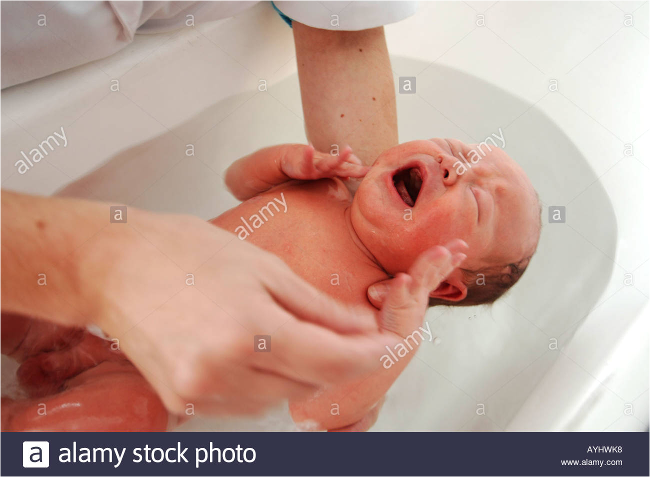 stock photo crying newborn one day old baby boy having his first bath