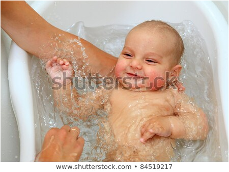 stock photo cute baby boy enjoying bath laughing while splashing water