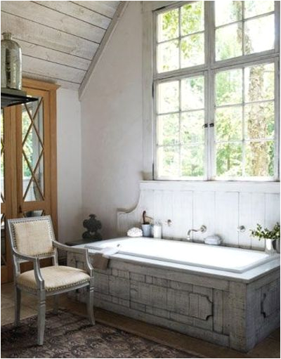 bathroom white washed wood plank ceiling unique wooden tub surround swedish chair large windows french doors mercury glass
