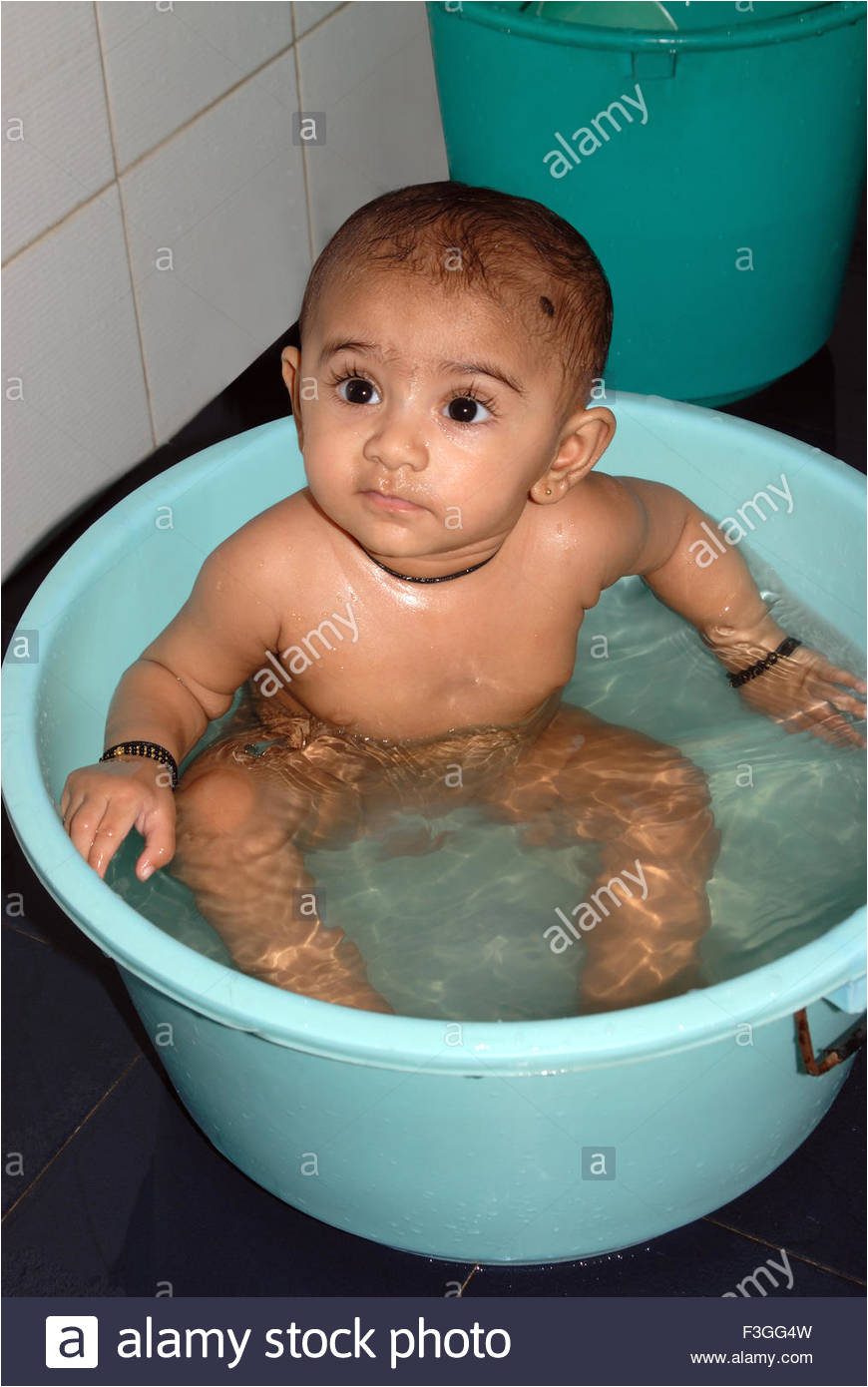 stock photo south asian indian baby taking bath in tub bathroom looking at side