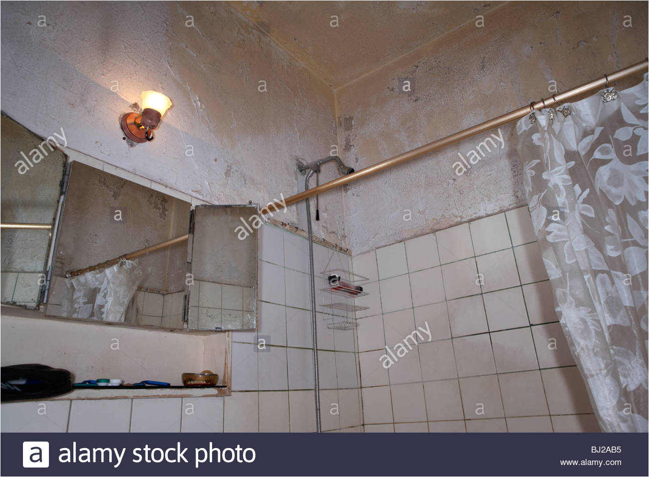 stock photo peeling paint on the ceiling above the shower in a run down bathroom