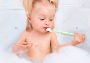 Baby Bath Tub for 2 Years Old Two Year Old Girl Taking A Bath and Brushing Teeth Stock