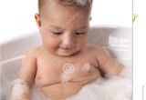 Baby Girl Bathtubs Baby Girl is Looking at Bubbles In Bathtub with F Stock