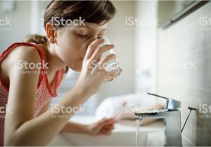 Bathtub Liner for Drinking Water Teenage Girl Drinking Water while Holding toothbrush In